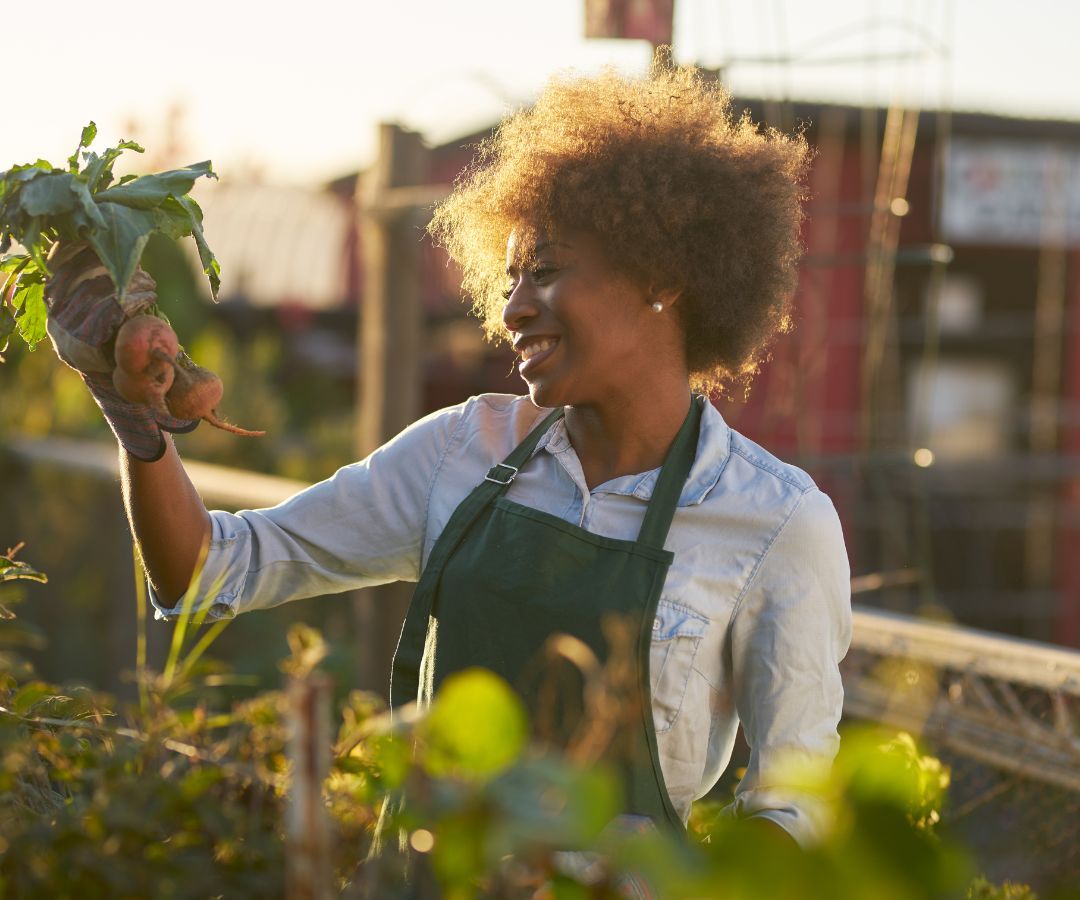 Femme tenant des betteraves qu'elle a cultivées