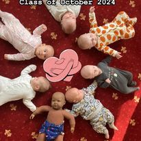 a photo of a 4 women with babies on yoga mats in front of them. In the middle is a soft rug with a selfie frame in the middle which has lots of yellow flowers.